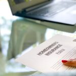 Woman reading a Homeowners Insurance Policy to be signed with laptop in background